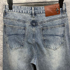 Light blue denim pants back view with two pockets and tan leather patch