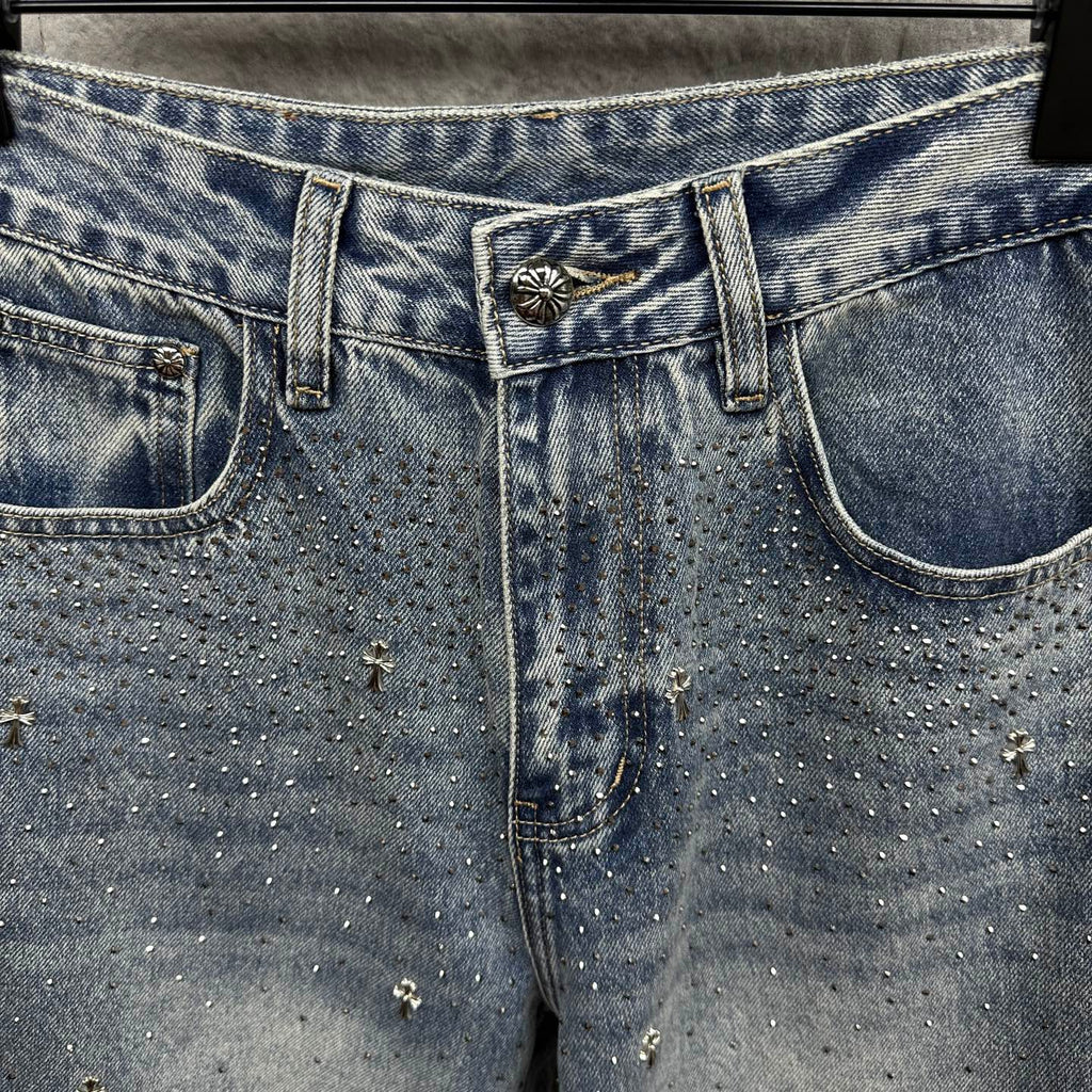 Light blue denim pants close-up of waistband and decorative patch at center