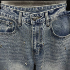 Light blue denim pants close-up of waistband and decorative patch at center