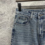 Light blue denim pants with left back pocket and scattered star-like embellishments