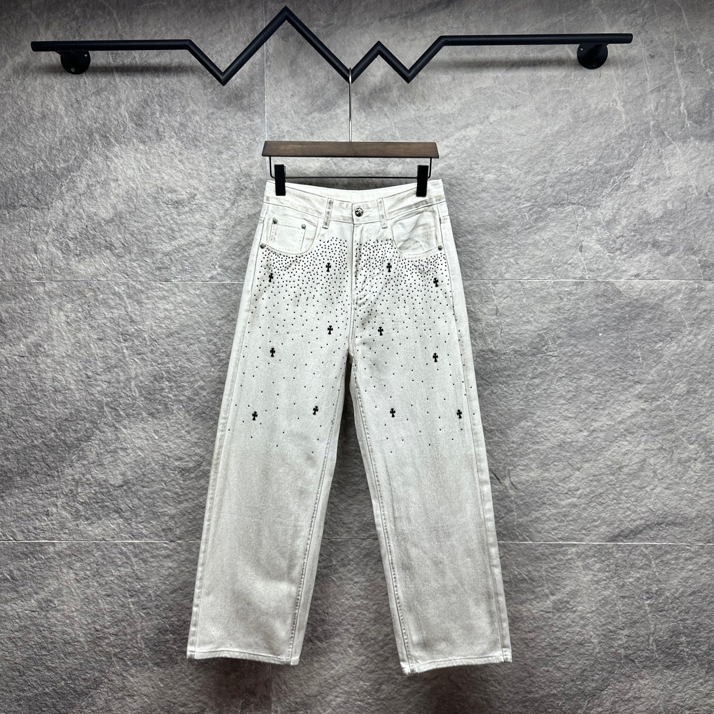 White denim pants with belt loops and all-over black dot cross pattern