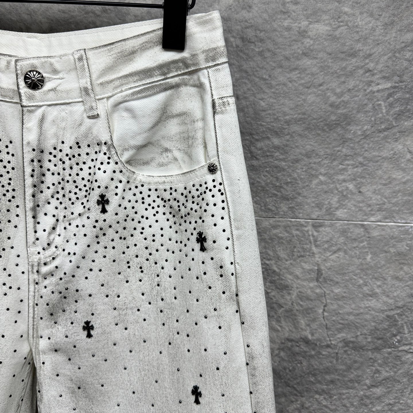 White denim pants with side pocket detail and black dot cross pattern
