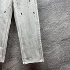 White denim pants lower legs with stitched seam and straight hem