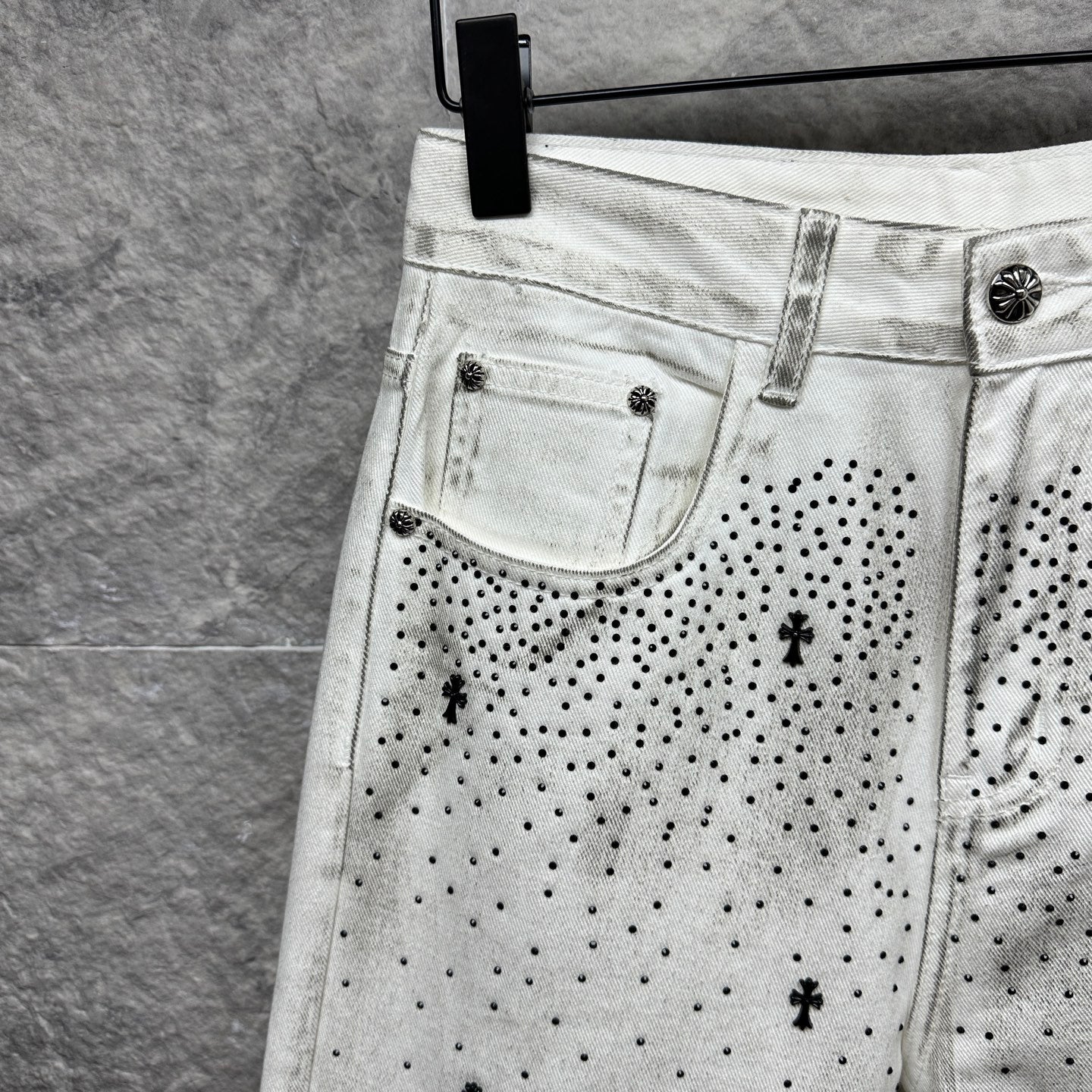 White denim pants with front curved pockets and black dot cross pattern