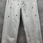 White denim pants with all-over black dot and cross print on legs