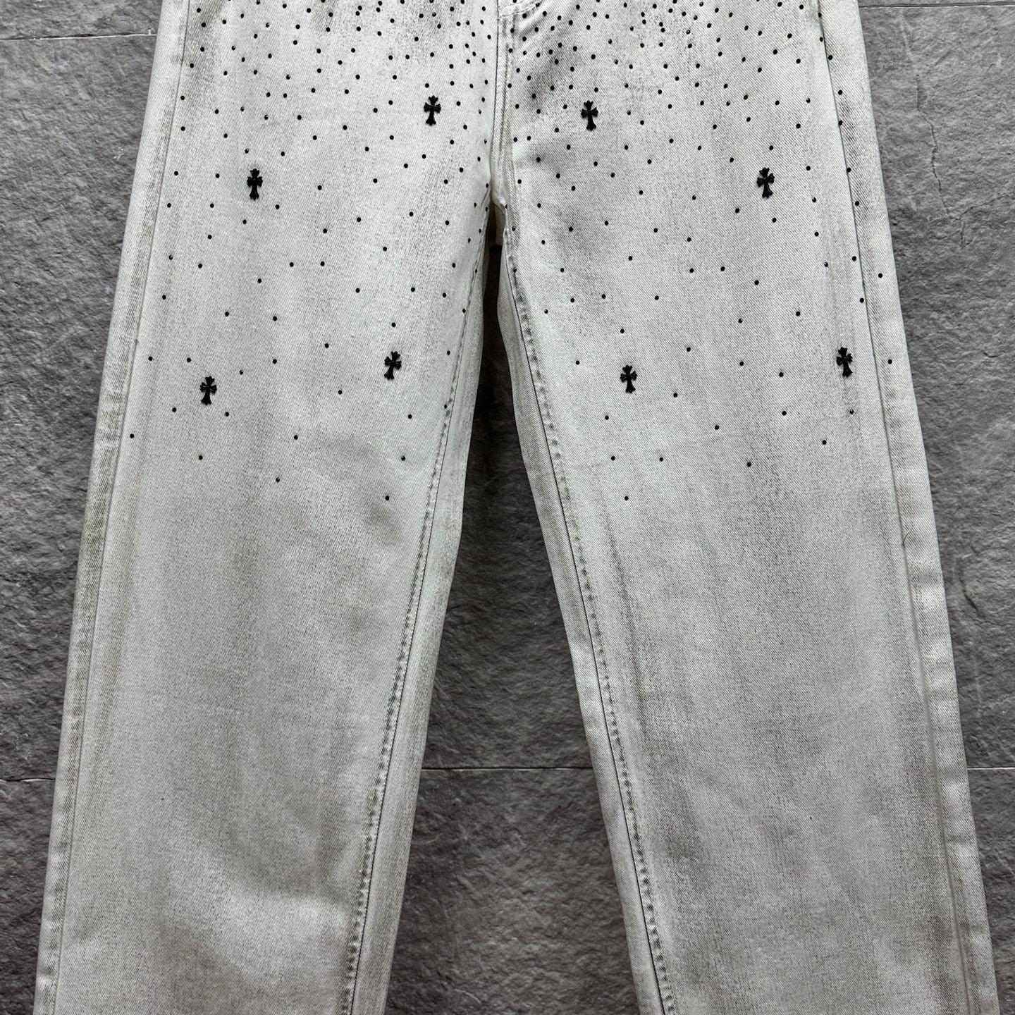 White denim pants with all-over black dot and cross print on legs