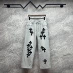 Light wash denim pants with black cross appliqués, button fly, belt loops