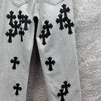 Light wash denim pants with black cross appliqués on front panels