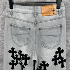 Light wash denim pants with back pockets and black cross appliqués, tan waist patch