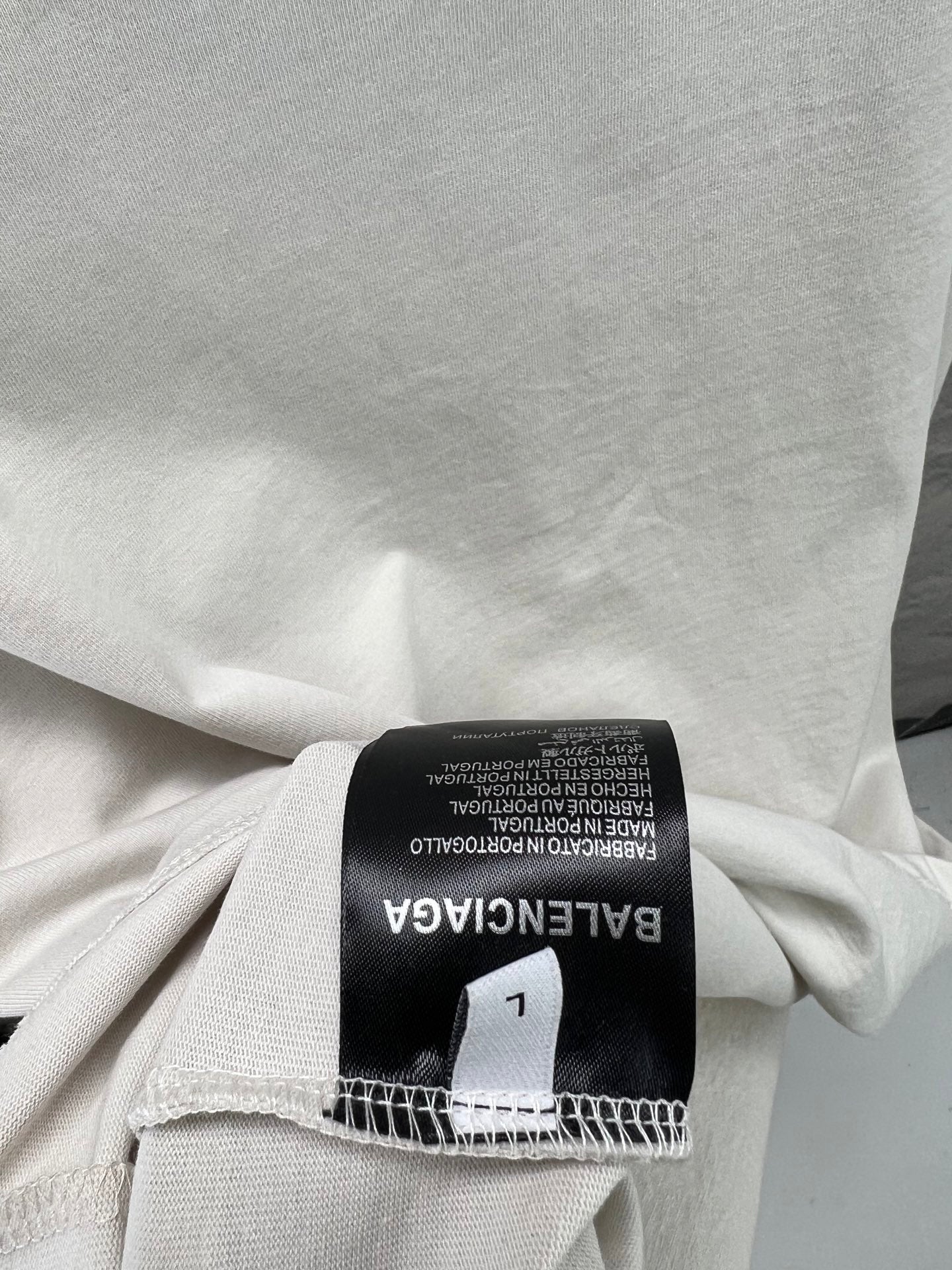 White T-shirt fabric label: black Balenciaga tag with size and care info