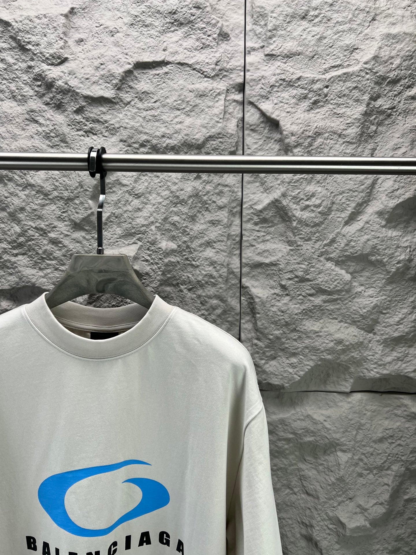 White crew-neck T-shirt with blue Balenciaga logo graphic at chest