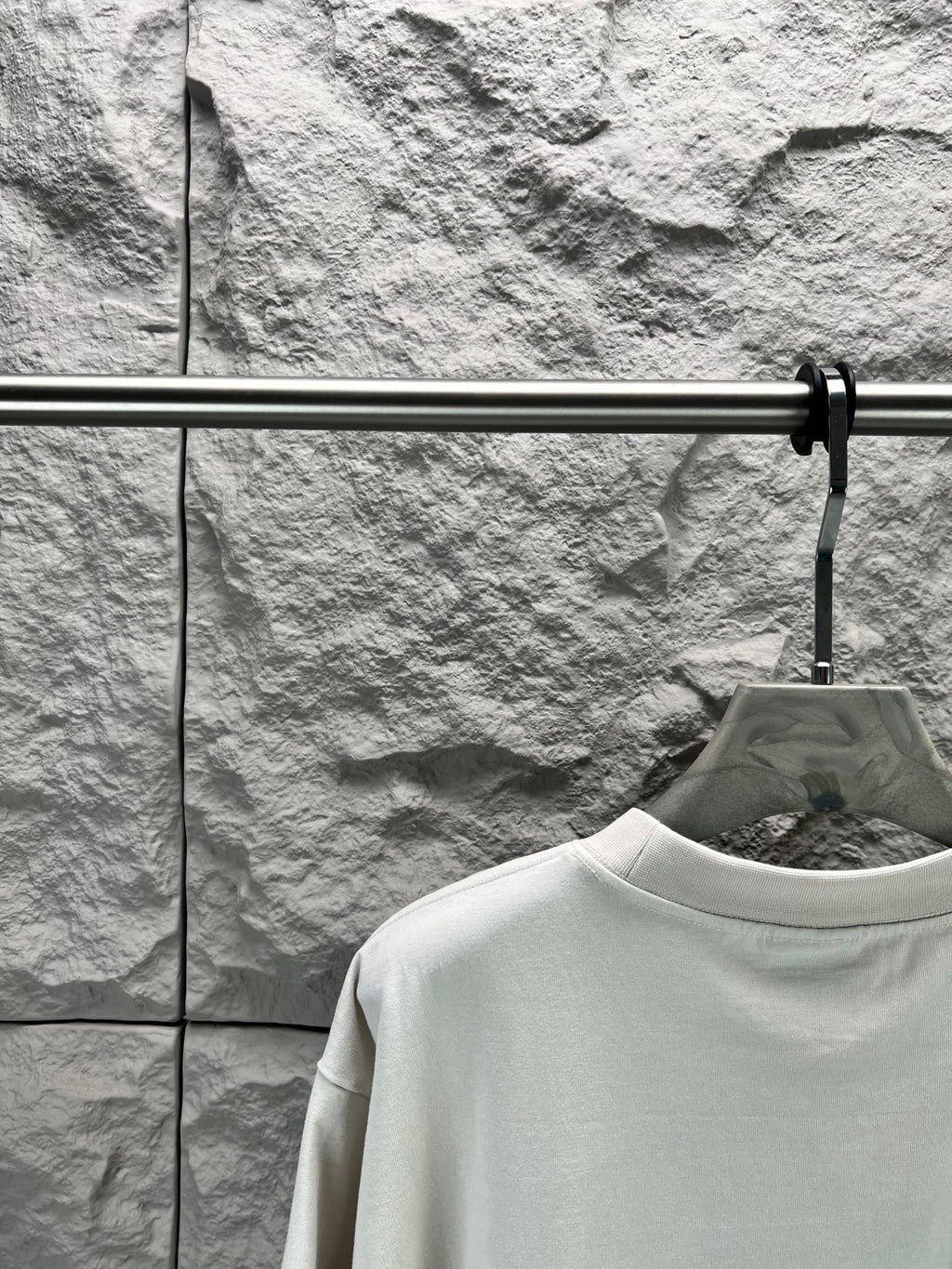 White crew-neck T-shirt neckline detail on a hanger