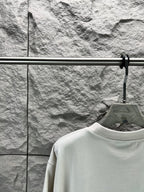 White crew-neck T-shirt neckline detail on a hanger