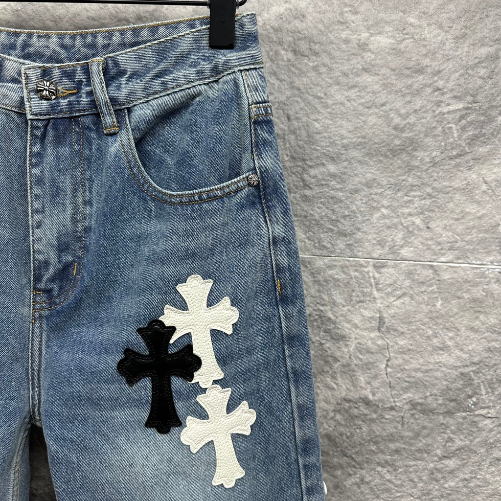 Light blue denim pants close-up of back pocket and large cross applique on leg