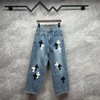 Light blue denim pants with scattered black and white cross applique designs