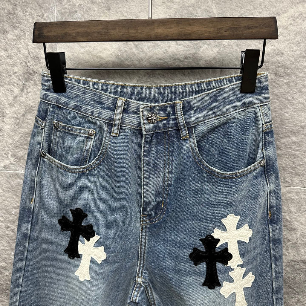 Light blue denim pants close-up: front pockets and waistband with cross applique
