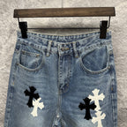 Light blue denim pants close-up: front pockets and waistband with cross applique