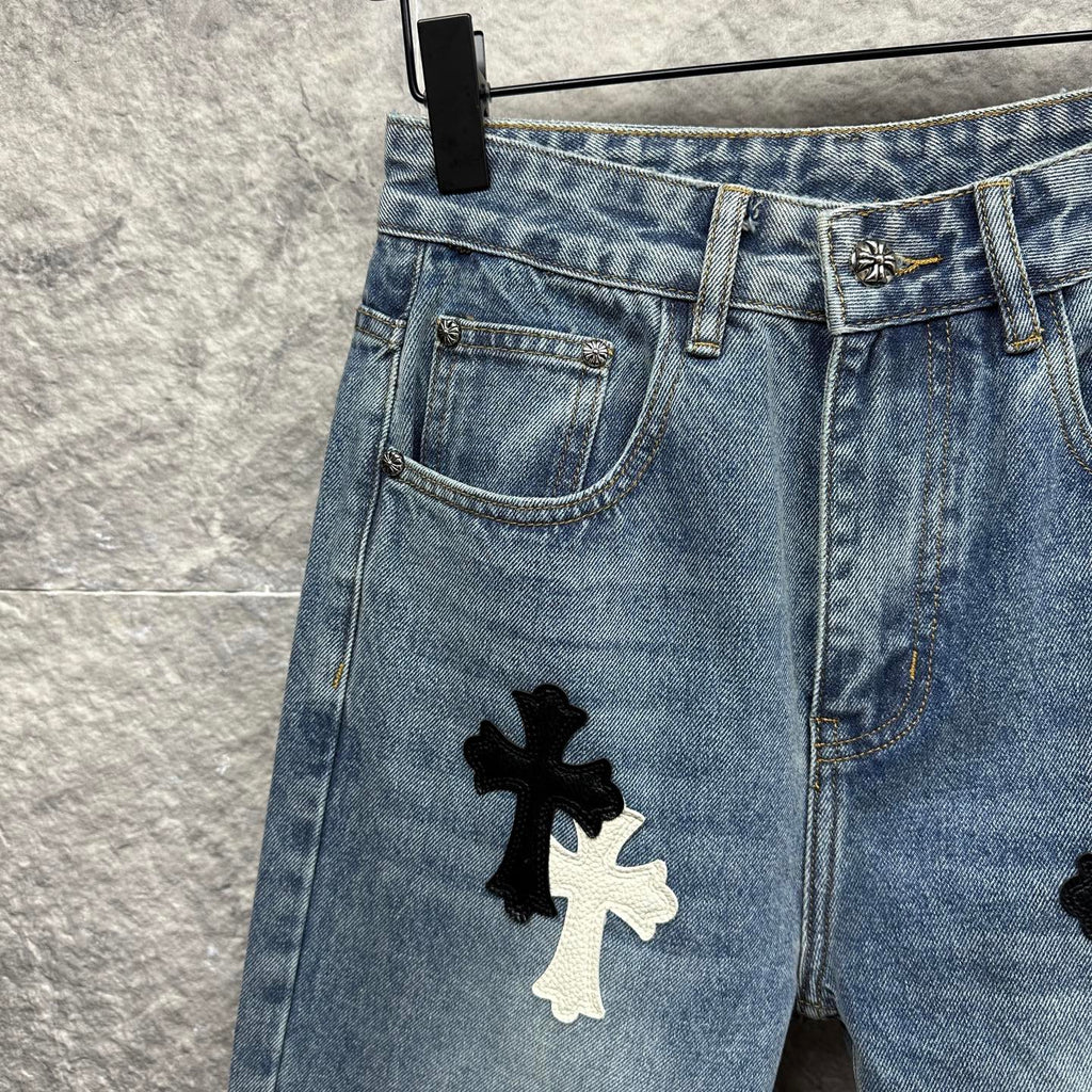 Light blue denim pants close-up of front pocket and thigh with cross applique