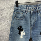 Light blue denim pants close-up of front pocket and thigh with cross applique