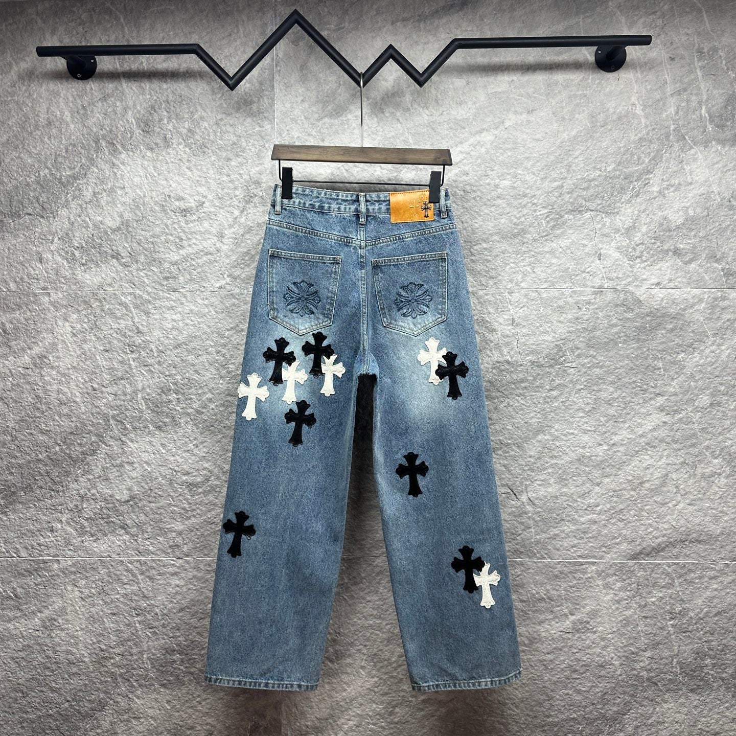 Light blue denim pants with all-over black and white cross applique patches