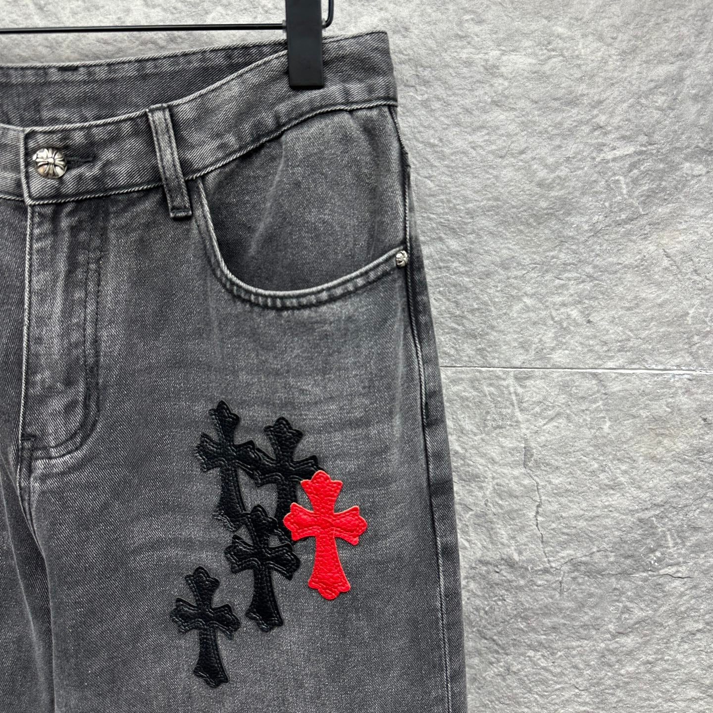 Grey denim pants with cross embroidery near side thigh and hem