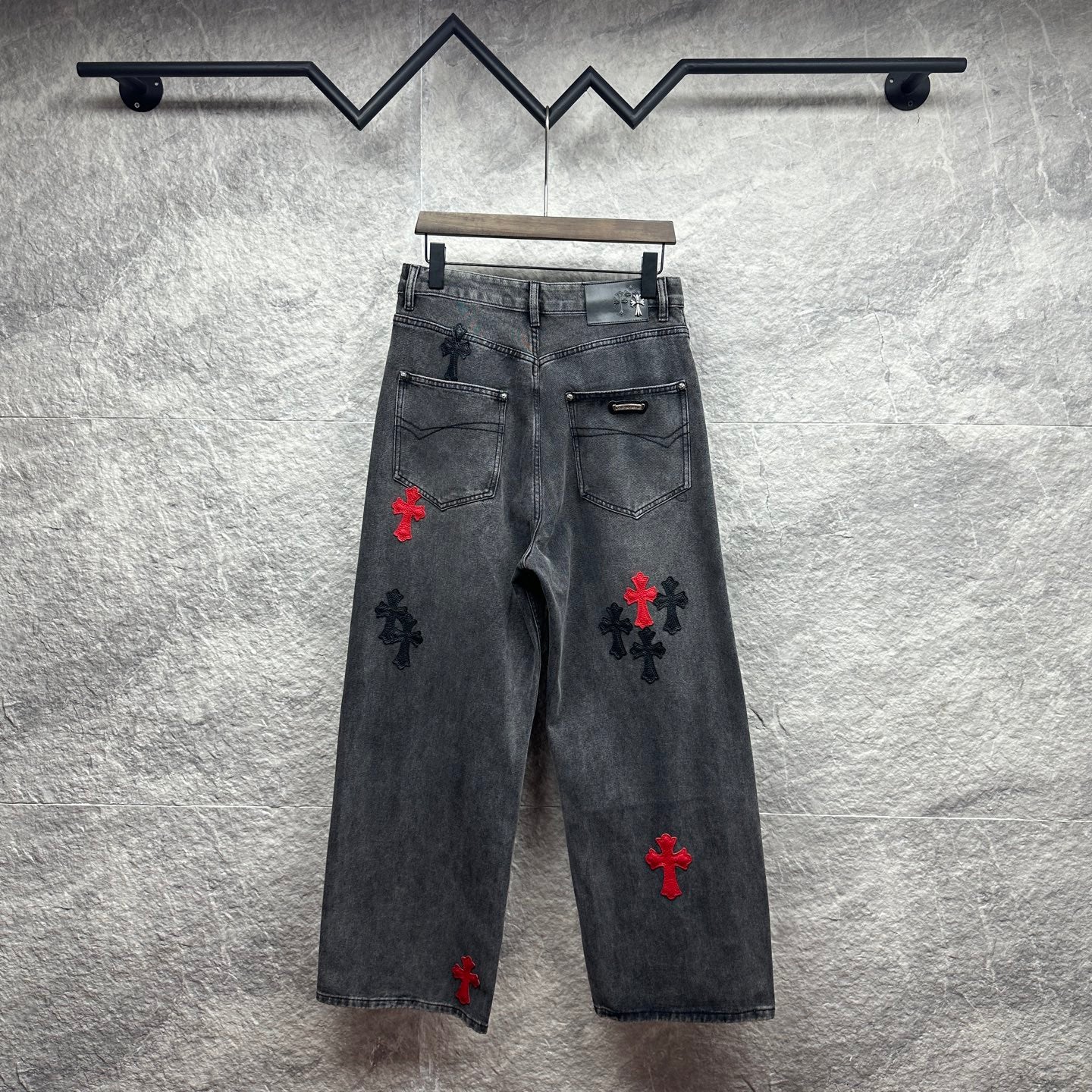 Grey denim pants with cross embroidery in red and black, back view
