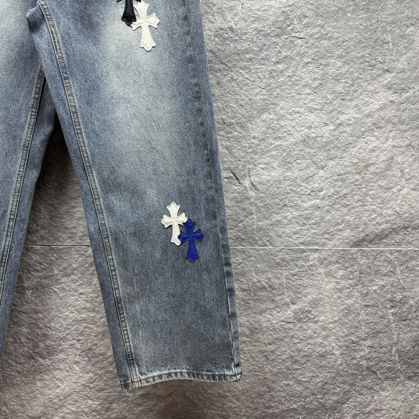 Light-wash denim pants with cross patches on the side seam, straight leg