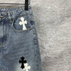 Light-wash denim pants with cross patches near pockets and lower leg