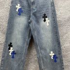 Light-wash denim pants with multiple cross patches on the front, full front view