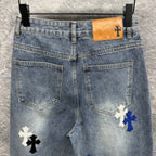 Light-wash denim pants with cross patches and tan logo patch at waistband