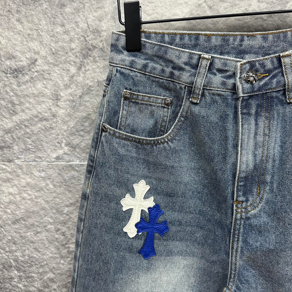 Light-wash denim pants with a large cross patch on the thigh, front pocket