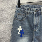 Light-wash denim pants with a large cross patch on the thigh, front pocket
