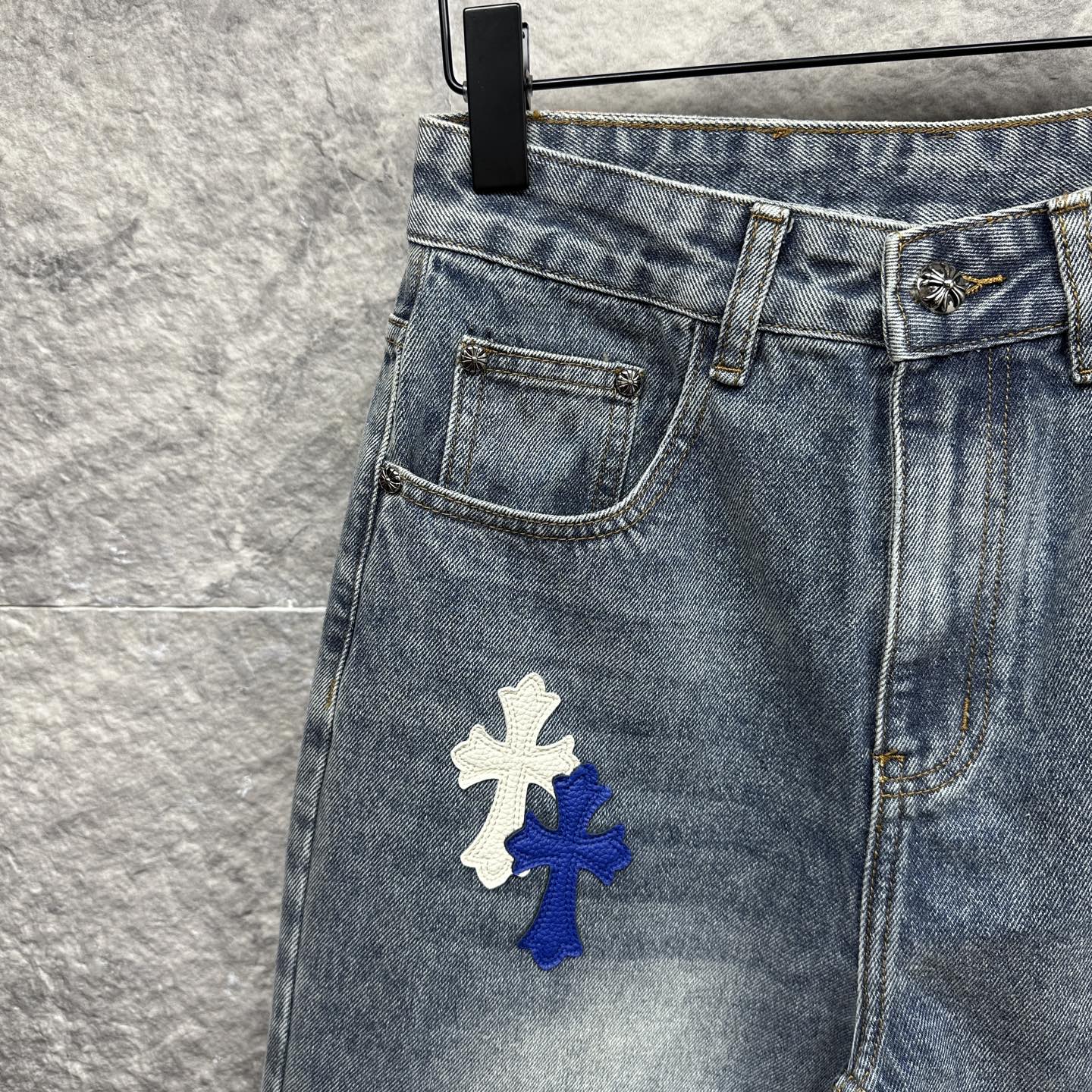 Light-wash denim pants with a large cross patch on the thigh, front pocket