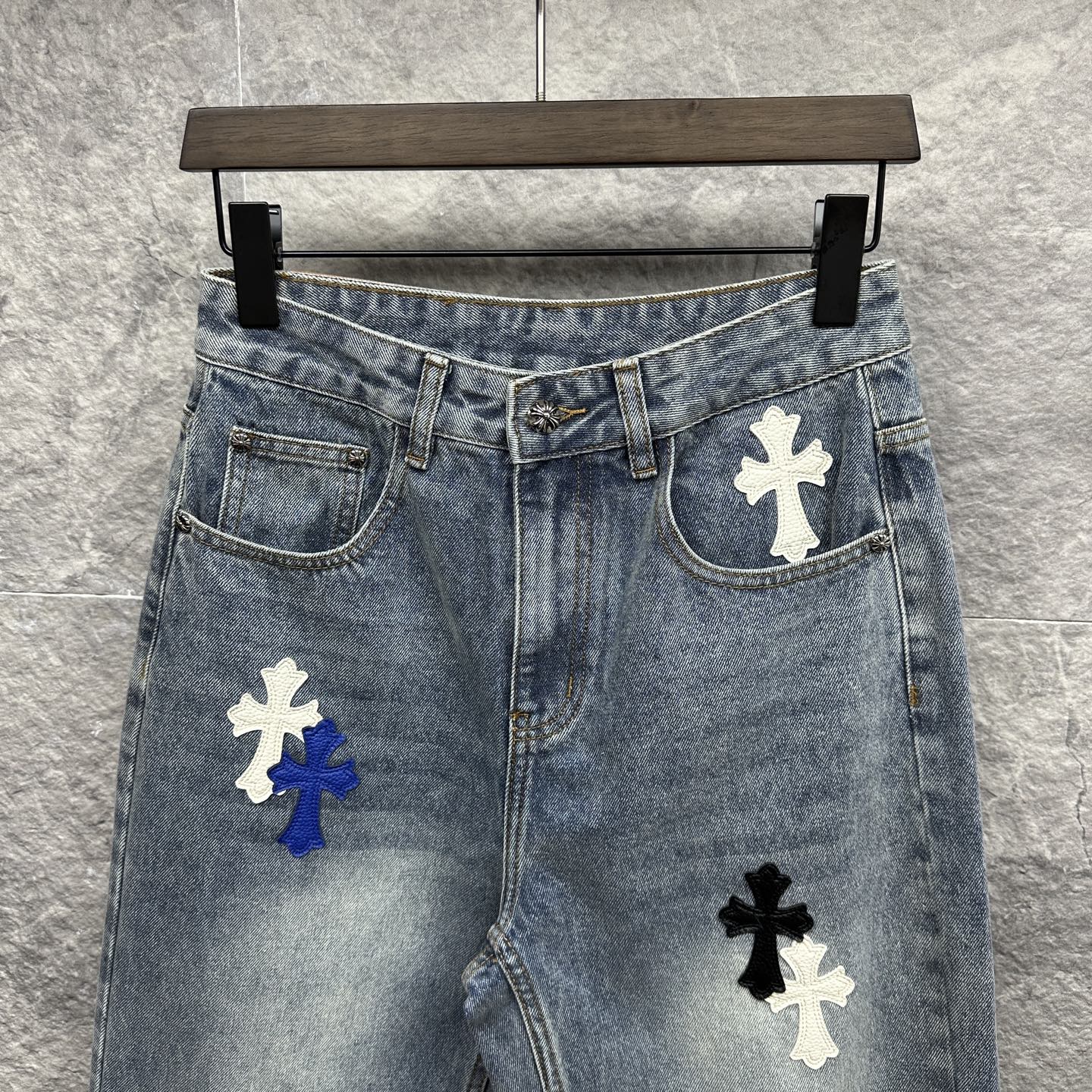 Light-wash denim pants with cross patches on the front, mid-rise waistband