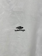 Close-up of white T-shirt fabric with small black Balenciaga logo.