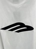 Close-up of large black logo graphic on a white crew-neck T-shirt.