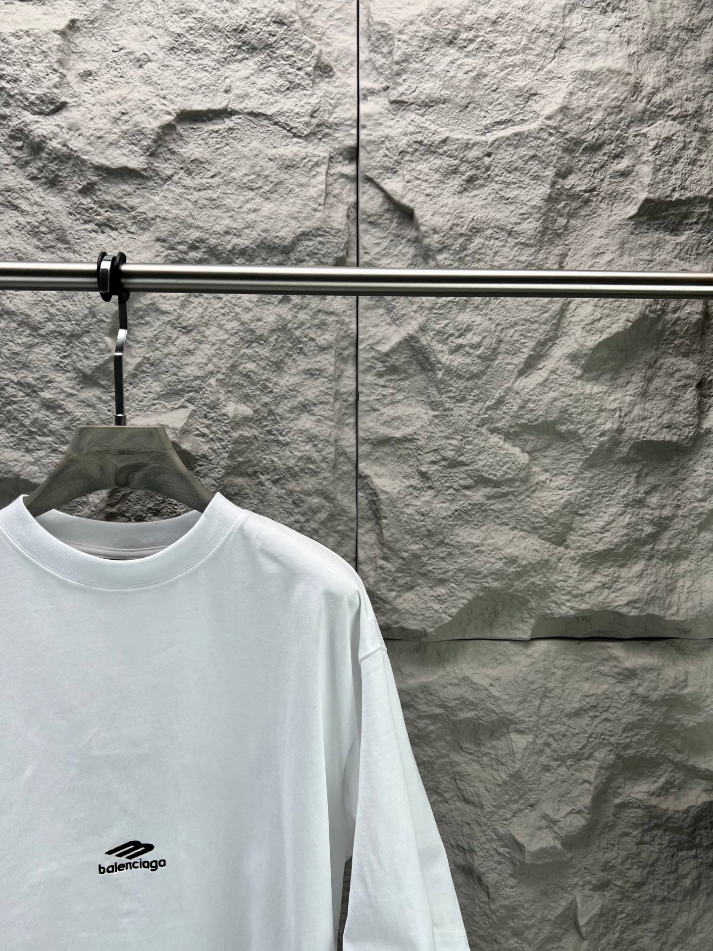 White crew-neck T-shirt with small chest logo; short sleeves and crew collar.