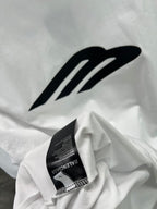 White crew-neck T-shirt with large black logo and woven neck label.