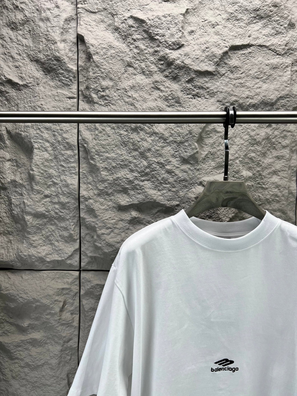 White crew-neck T-shirt with small chest logo and relaxed shoulder fit.