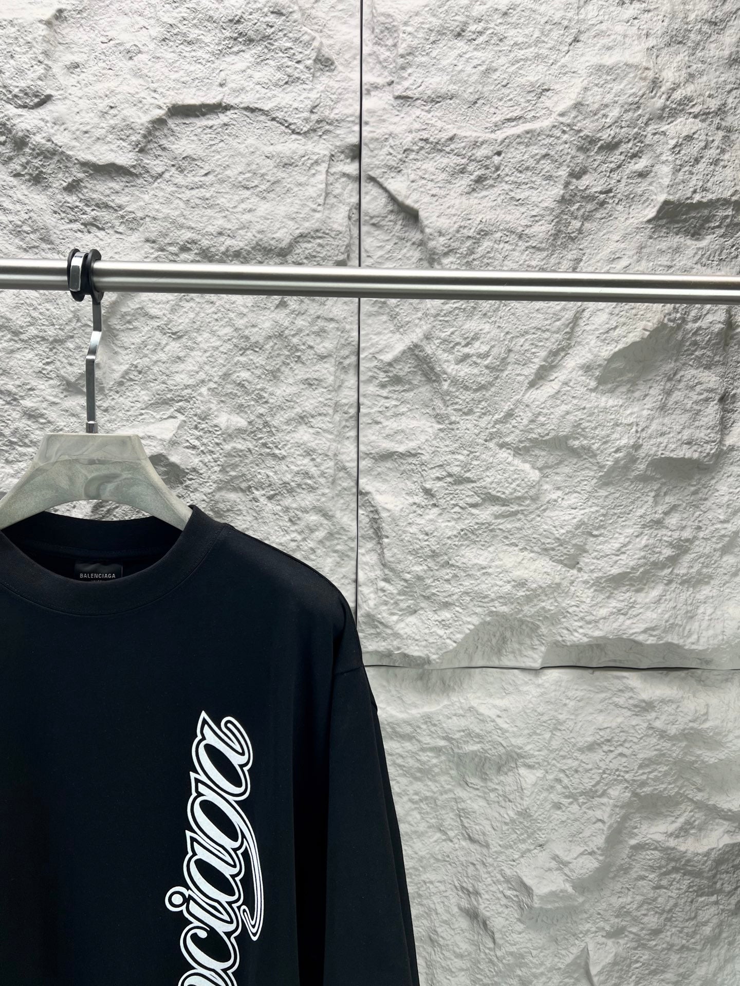 Black short-sleeve T-shirt with Balenciaga script logo, angled shoulder view