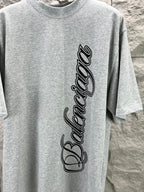 Light blue short-sleeve T-shirt with Balenciaga script logo, close-up