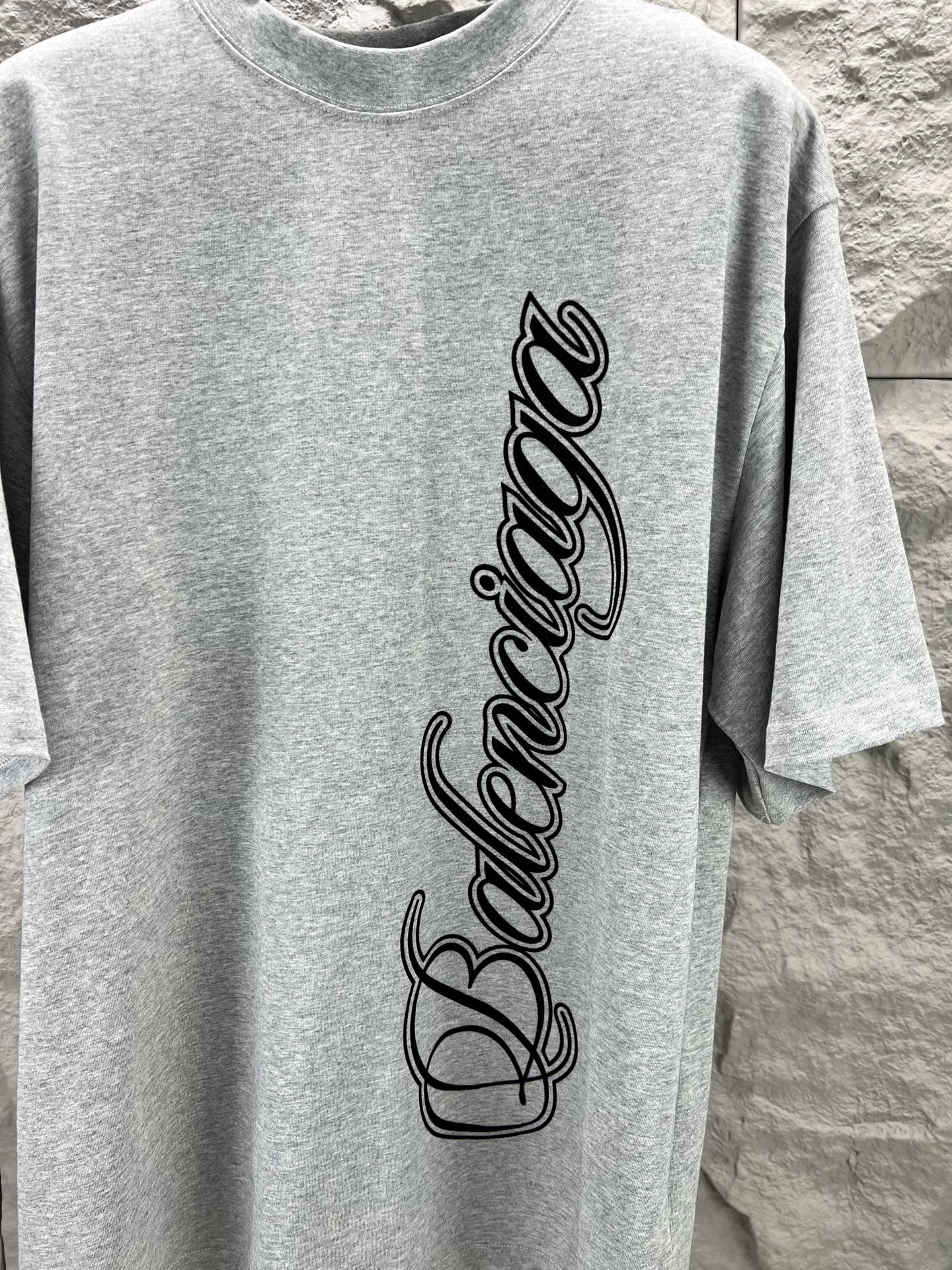 Light blue short-sleeve T-shirt with Balenciaga script logo, close-up
