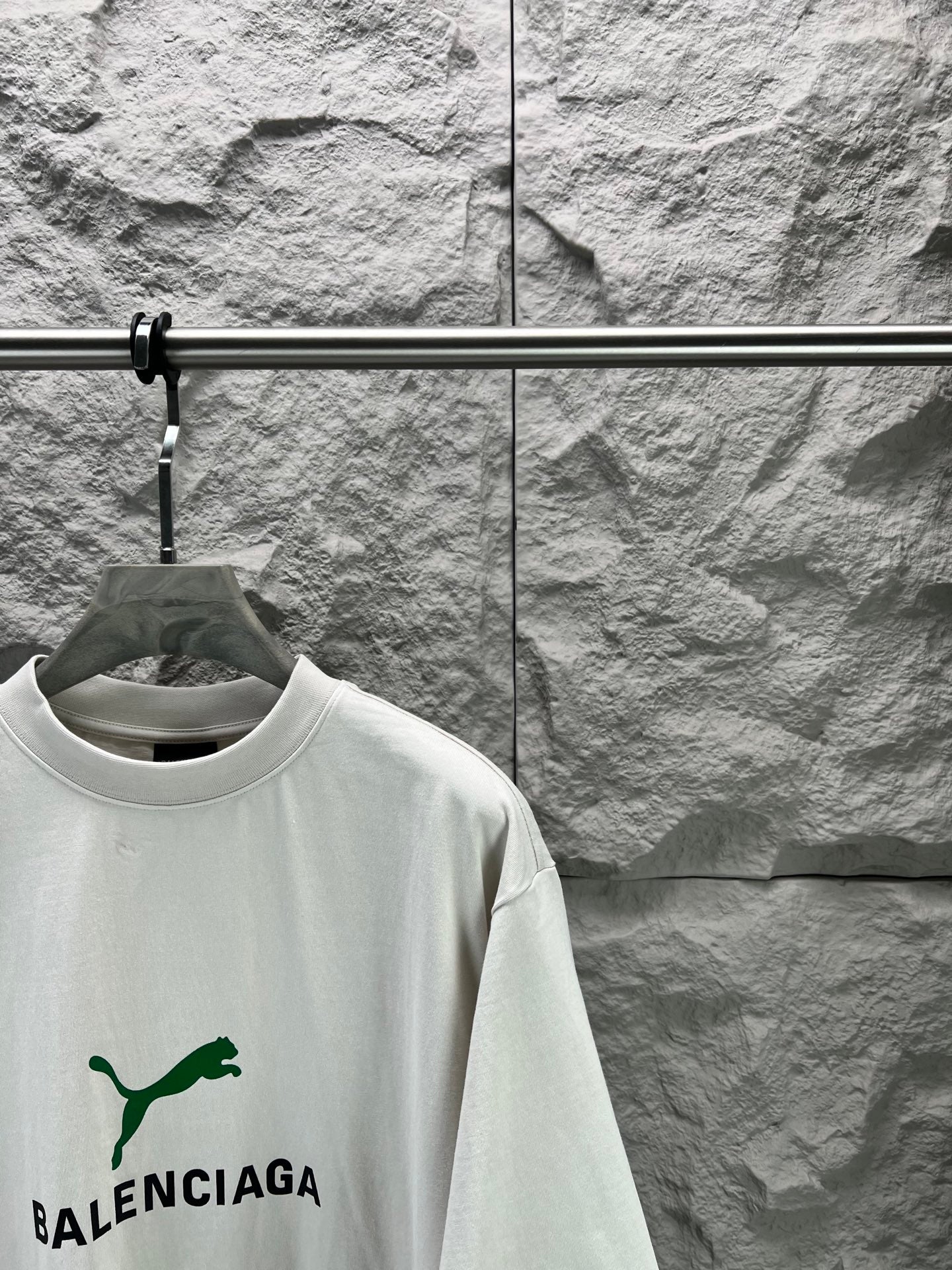 Light gray short-sleeve T-shirt front angled view with green Balenciaga logo