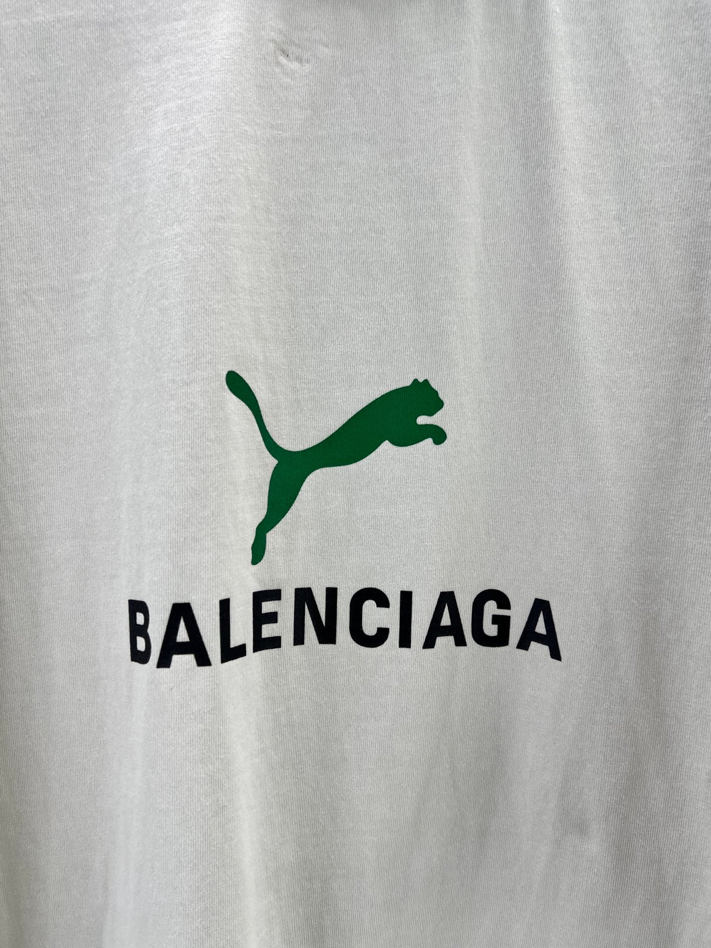 Light gray T-shirt close-up of green Balenciaga logo print