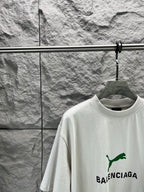 Light gray short-sleeve T-shirt front close-up with green Balenciaga logo