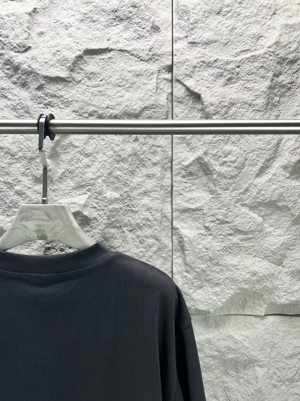 Balenciaga dark navy T-shirt back view, collar area on hanger