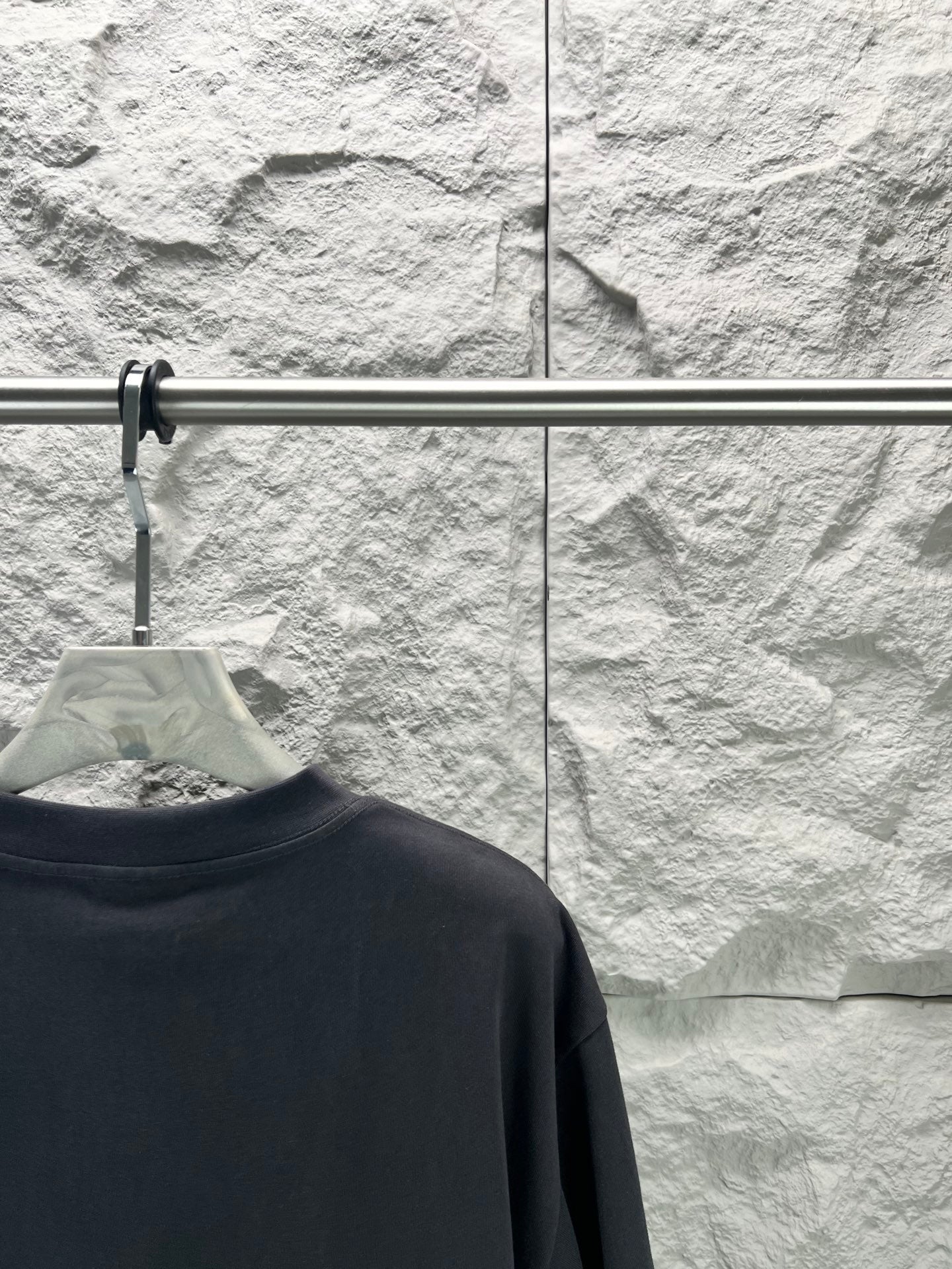 Balenciaga dark navy T-shirt back view, collar area on hanger