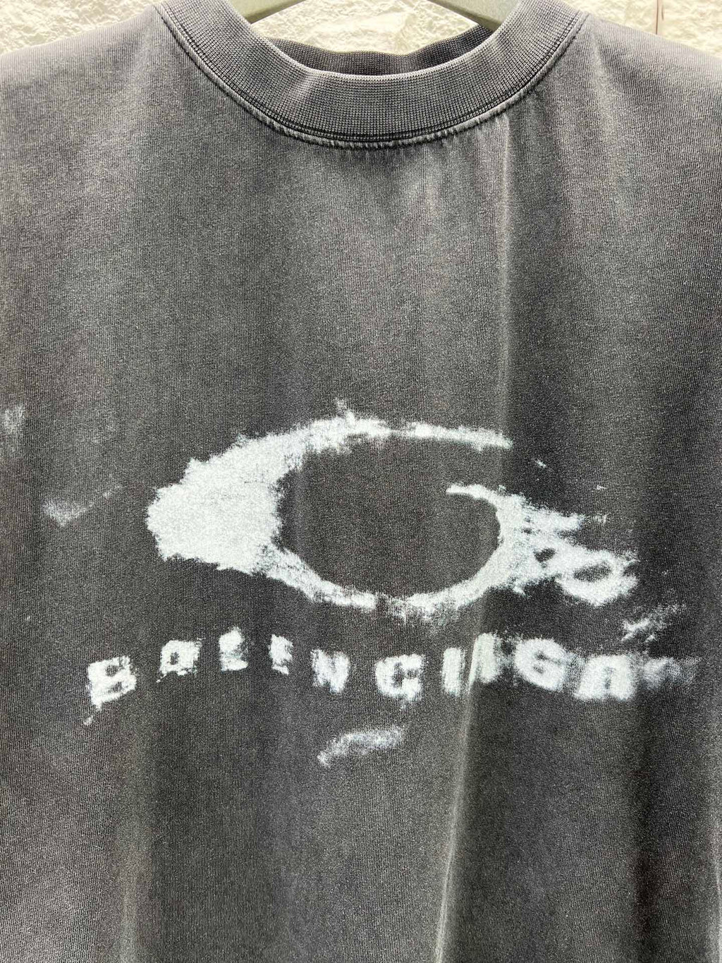 Dark short-sleeve T-shirt close-up of distressed oval and BALENCIAGA print
