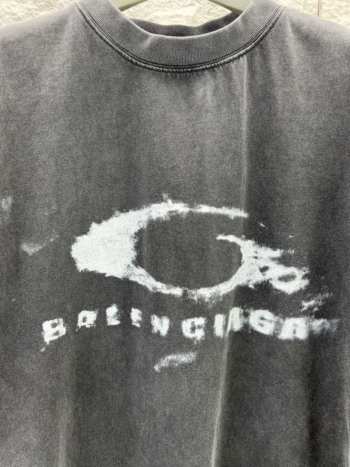 Dark short-sleeve T-shirt close-up of distressed oval and BALENCIAGA print
