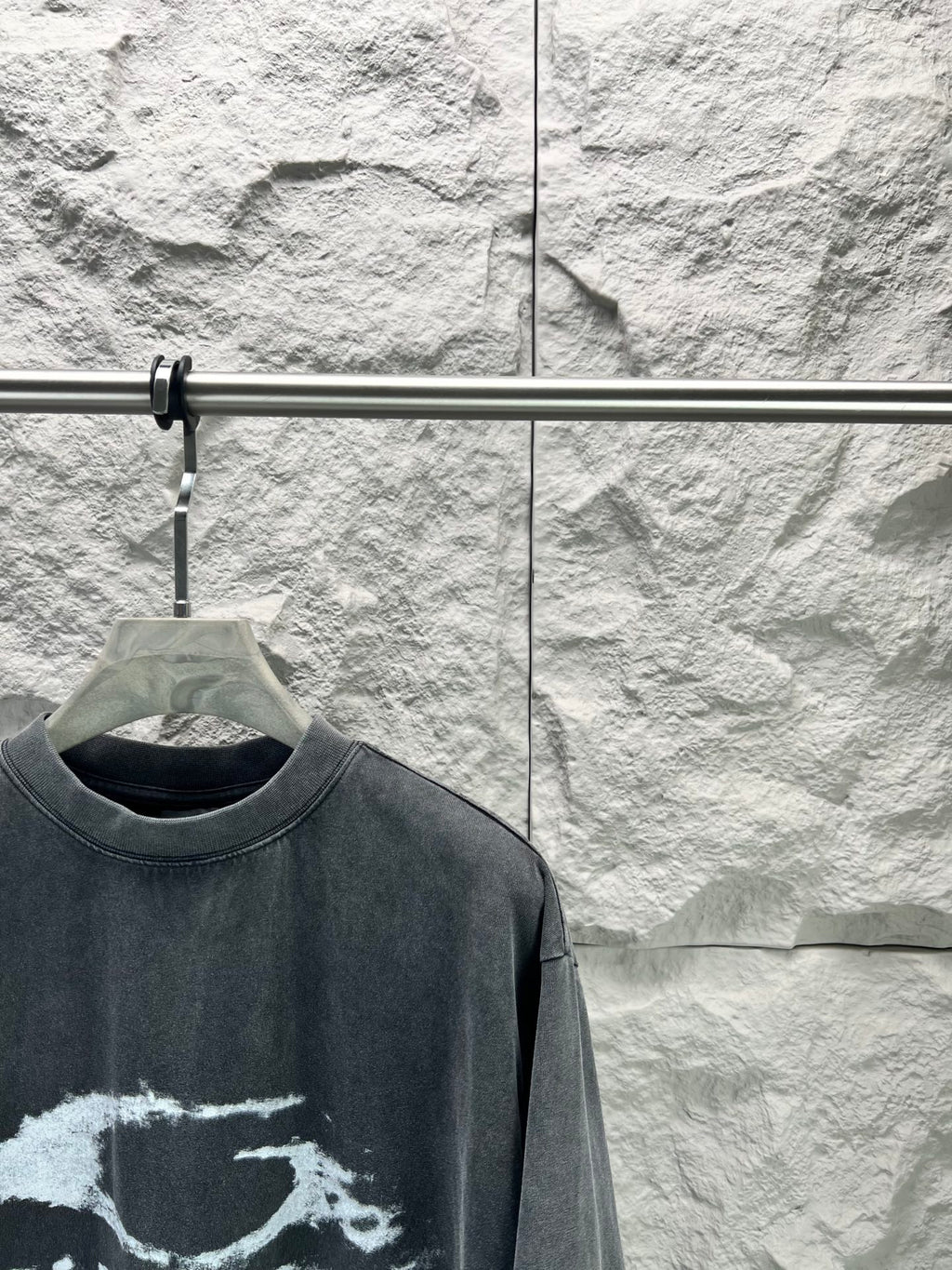 Dark short-sleeve T-shirt close-up of crew neck and partial distressed logo